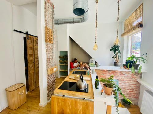 a kitchen with a sink and a brick wall at Tiny Beachhouse in Scheveningen
