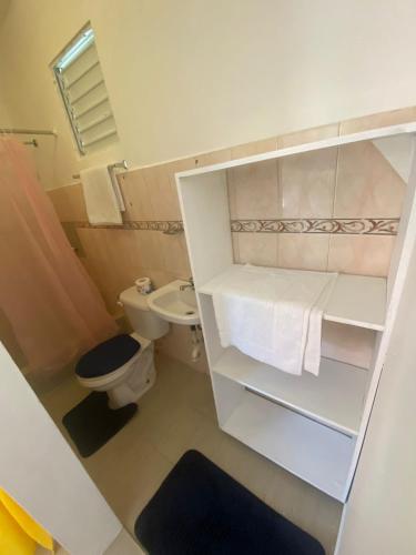 a small bathroom with a toilet and a sink at Hotel el Escondite in Las Terrenas