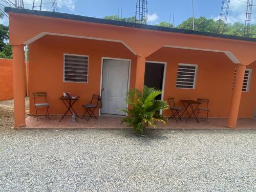 a small orange house with chairs and a table at Hotel el Escondite in Las Terrenas