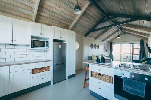 a kitchen with white cabinets and a black refrigerator at Lakeside Mountain Loft in Lakeside