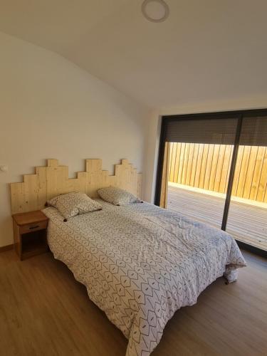 Schlafzimmer mit einem großen Bett mit einem Kopfteil aus Holz in der Unterkunft Bassin d'Arcachon Villa 10 couchages in Andernos-les-Bains