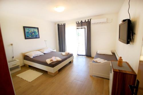 a bedroom with two beds and a flat screen tv at The Peaceful Vacation in Metajna