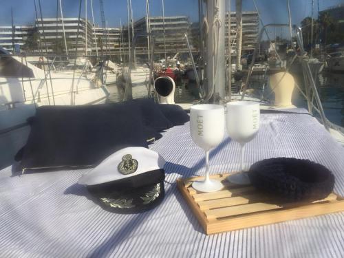 a table with a hat and glasses on a boat at Velero en Port Forum sail boat in Barcelona