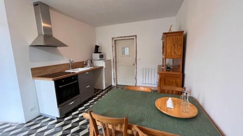 a kitchen with a table and a kitchen with a sink at Chez Loulou - La suite in Lainsecq