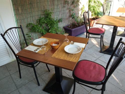 una mesa de madera con sillas y platos. en Agriturismo Vecchio Frantoio en Villatella