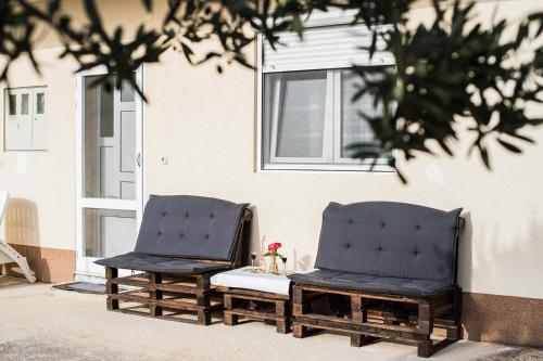 duas cadeiras sentadas em frente a um edifício em Kuća za odmor Boris em Podstrana