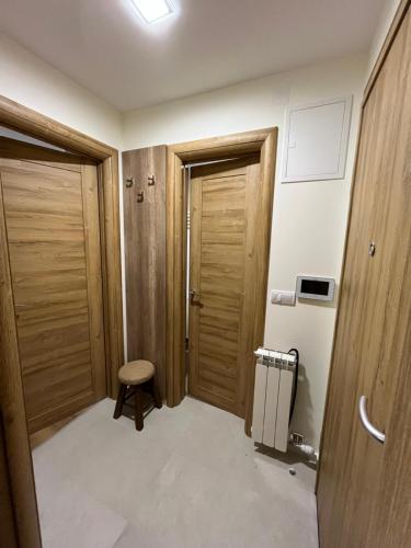a room with two wooden doors and a stool at Apartmani Twins Zlatibor in Zlatibor