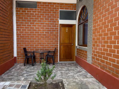 a patio with a table and chairs next to a brick building at Los Gavilanes Hotel in Pucallpa