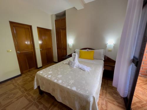 a bedroom with a bed with a towel on it at Los Gavilanes Hotel in Pucallpa