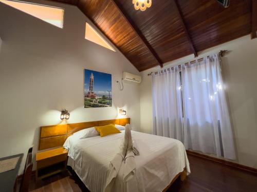 1 dormitorio con cama blanca y ventana en Los Gavilanes Hotel en Pucallpa