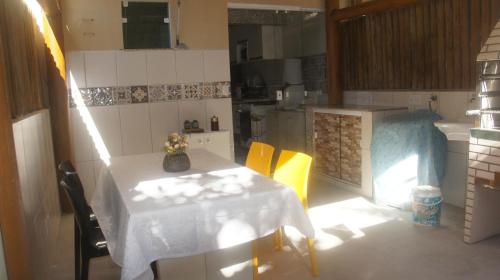 a small kitchen with a table and yellow chairs at Imbassai Summer Flats Village in Imbassai