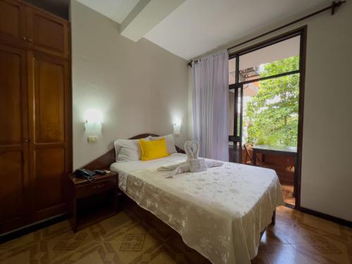 1 dormitorio con cama y ventana grande en Los Gavilanes Hotel en Pucallpa