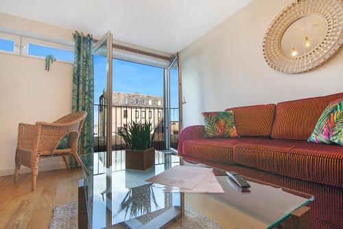 sala de estar con sofá rojo y mesa de cristal en Mearns Street Apartments - Grampian Lettings Ltd, en Aberdeen