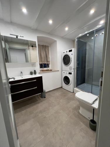 a bathroom with a sink and a washing machine at Podgora Experience Suite II in Nerezine