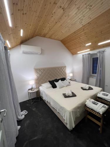 a bedroom with a large bed and a wooden ceiling at Podgora Experience Suite II in Nerezine