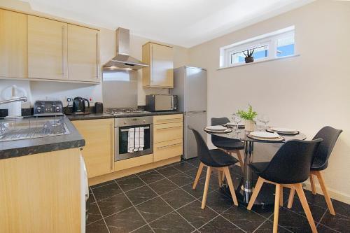 Mearns Street Apartments - Grampian Lettings Ltd في أبردين: مطبخ فيه طاولة وكراسي