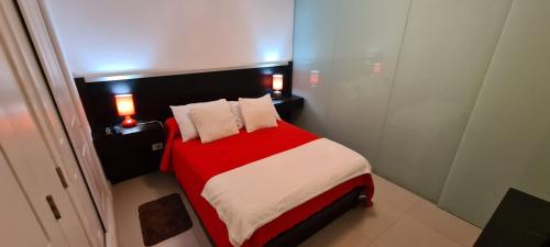 1 dormitorio con 1 cama roja y blanca con 2 almohadas en GREEN PARK 116E, en Punta del Este