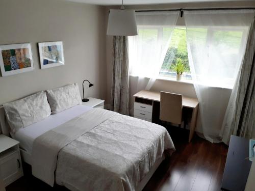 a bedroom with a bed and a desk and a window at Ensuite at the foot of Dublin Mountains in Dublin