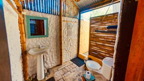 a bathroom with a toilet and a sink at The Mudhouse Hostel Mompiche in Mompiche