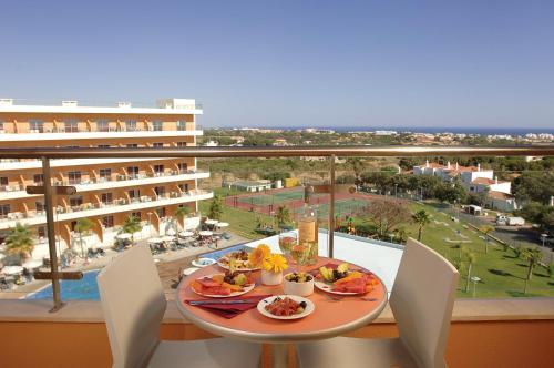 a table with food on a balcony with a view at Hotel Apartamento Balaia Atlantico in Albufeira
