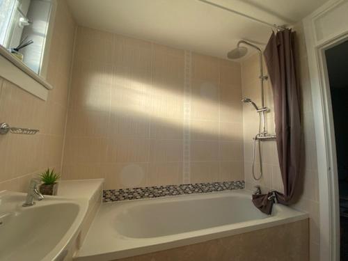 a bathroom with a bath tub and a sink at Burnt Island 2 bed apartment with stunning views in Fife