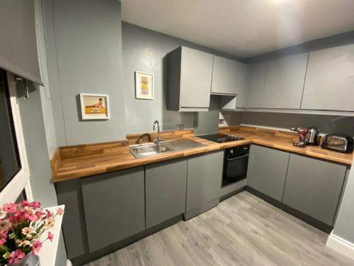 a kitchen with a sink and a counter top at Burnt Island 2 bed apartment with stunning views in Fife