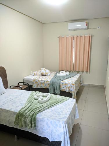 a room with two beds and a window at apartamento 2 da Cintia in Lençóis