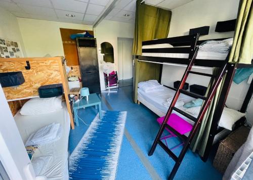 a dorm room with two bunk beds and a ladder at Spotsleeping in Anglet