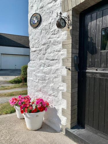 two flower pots on the side of a building with a door at Old Nursery in Coity