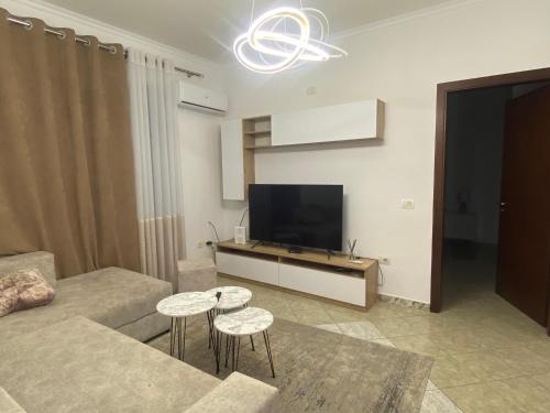 sala de estar con sofá y TV de pantalla plana en Guest House Open Room, en Durrës
