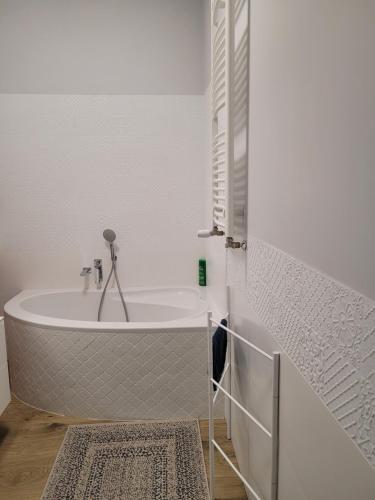 uma casa de banho branca com uma banheira e um tapete em Elegancki Apartament em Puławy