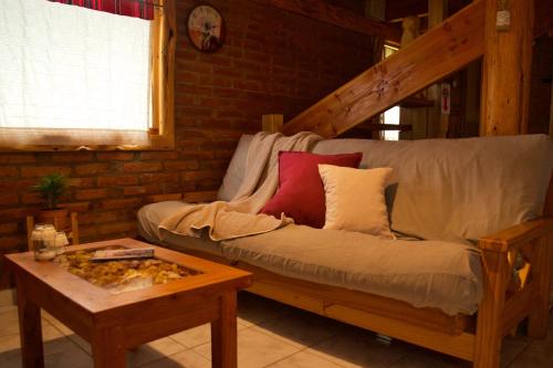 a living room with a couch and a table at Cabañas Casiopea Lago Puelo in Lago Puelo