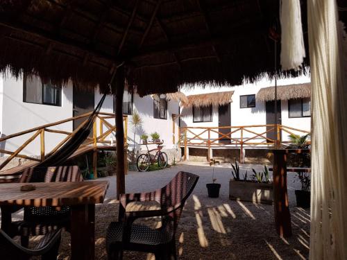 a patio area with chairs, tables and umbrellas at EncantaLuna in Holbox Island