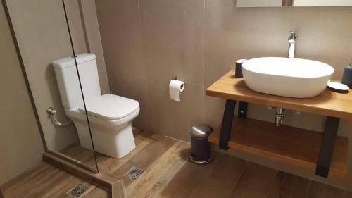uma casa de banho com um lavatório e um WC em Utopia suites em Egina