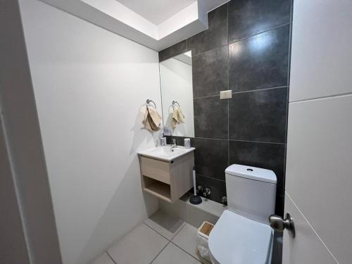 een badkamer met een wit toilet en een wastafel bij Departamento amoblado Chillán Centro in Chillán