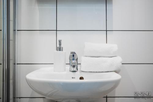 a white sink in a bathroom with towels at St. Michael's Apartments in Bournemouth