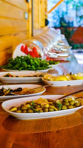 a buffet with plates of food on a table at Lemon Garden Lodge in Cıralı