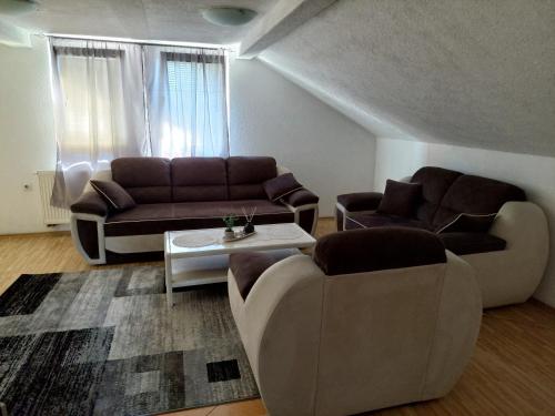 a living room with two couches and a table at Apartment EM 2 in Tuzla