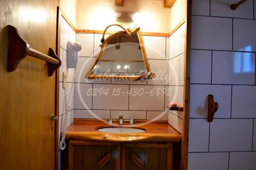 a bathroom with a sink and a mirror at Cabañas Willy in El Bolsón