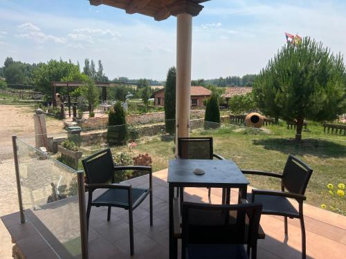 a patio with a table and chairs and a view of a field at El BURGO DE OSMA ALOJAMIENTO RURAL VILLA BAGH in El Burgo de Osma
