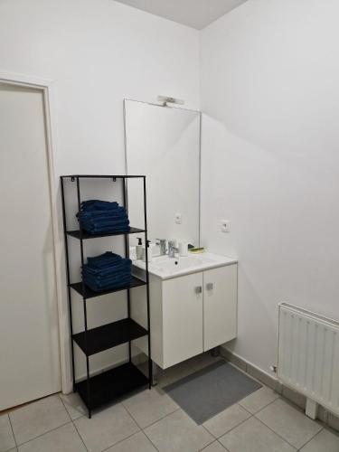 une salle de bain blanche avec un lavabo et un miroir dans l'établissement Appartement 20mn Paris Saint Lazare (4 personnes), à Argenteuil