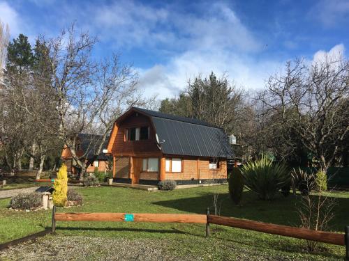 a house with a fence in front of it at Cabañas Casiopea Lago Puelo in Lago Puelo