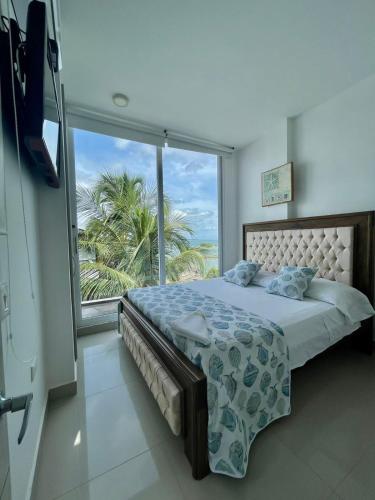 a bedroom with a bed and a large window at Costa Serena Casa 3 in Coveñas