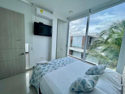 1 dormitorio con cama y ventana grande en Costa Serena Casa 3, en Coveñas
