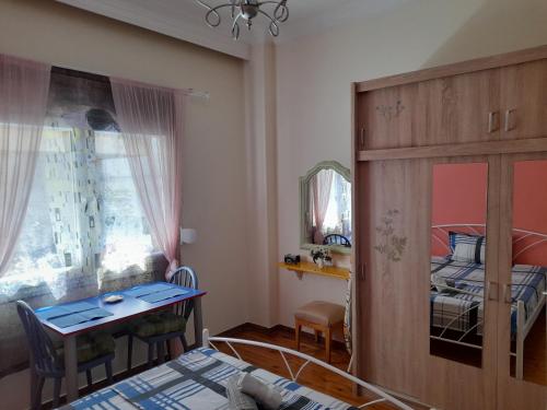 a small room with a bed and a table and a bedroom at Sweet Home in Thessaloniki