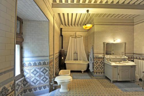 La salle de bains est pourvue de toilettes, d'une baignoire et d'un lavabo. dans l'établissement Château De Vollore, à Vollore-Ville