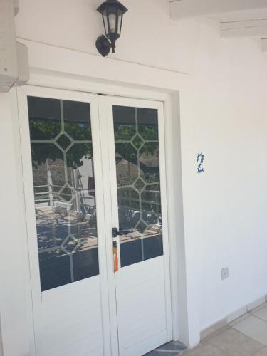 a white door with windows in a room at Rosemary House in Sarandë
