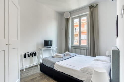 een witte slaapkamer met een bed en een raam bij Appio Deluxe Apartment in Rome