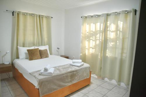 a bedroom with a bed and a window with curtains at FonteinZen - Home with big garden at Fontein in Willemstad