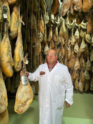 a man in a lab coat standing in front of a pile of meat at LA CASITA DE BAUTISTA 2 llaves montanchez -caceres in Montánchez